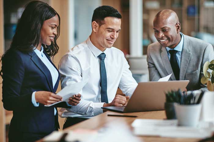 three smiling people in business attire